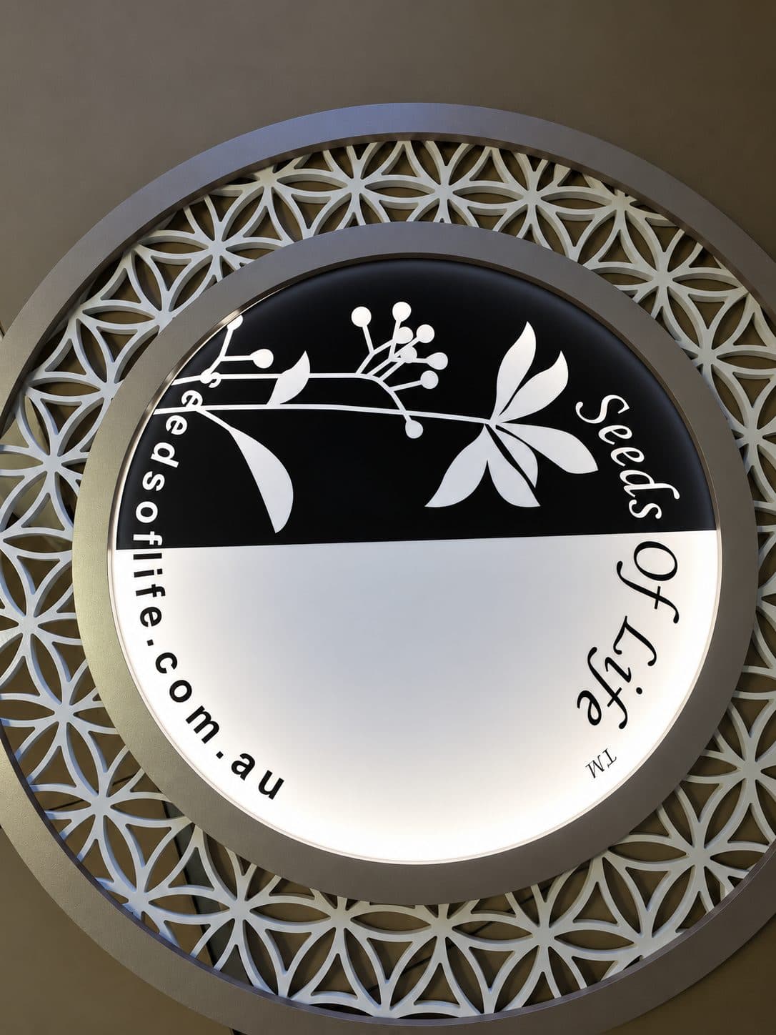Round illuminated sign set into a decorative routed surround