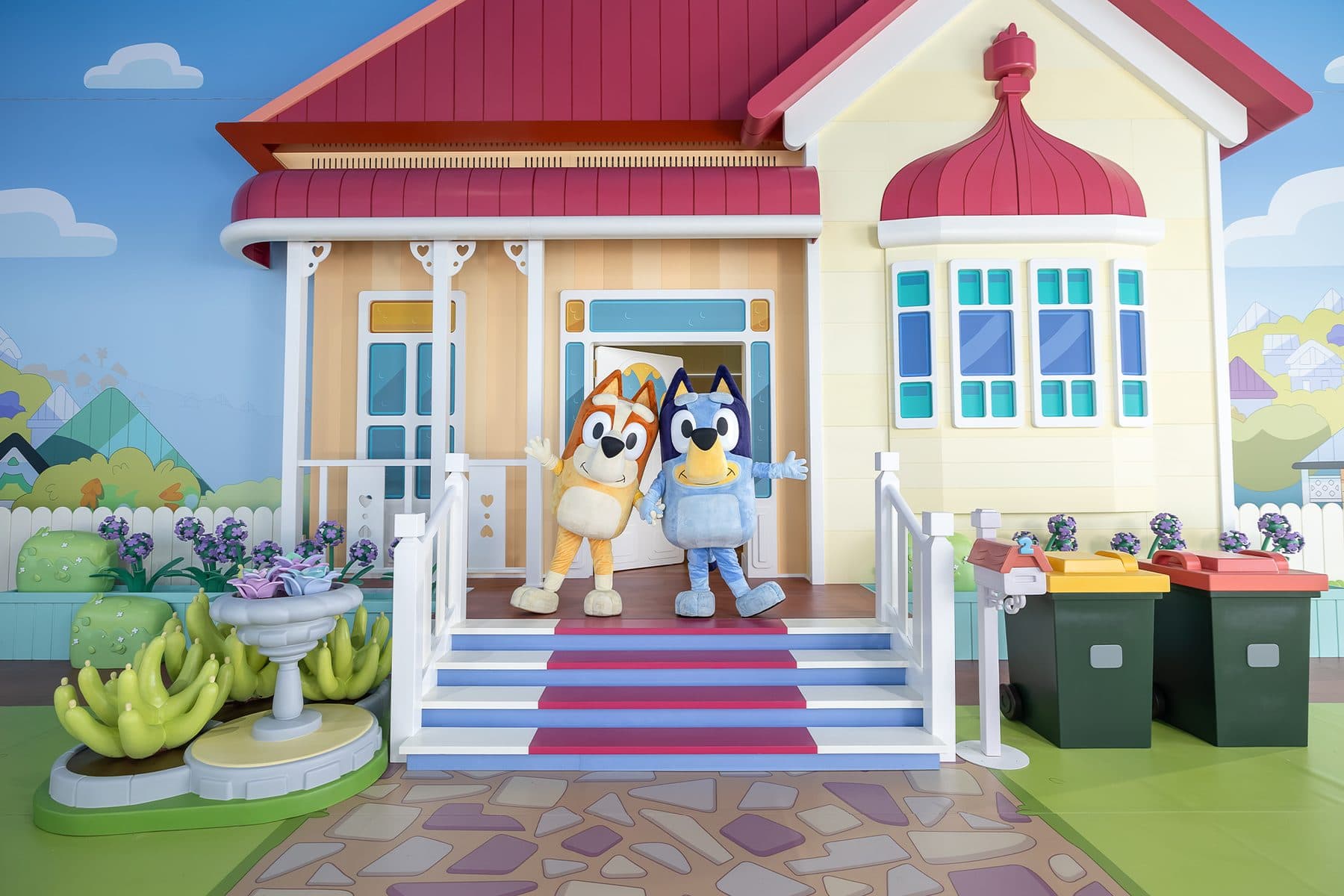 Built house facade against a printed scenic backdrop at a family attraction