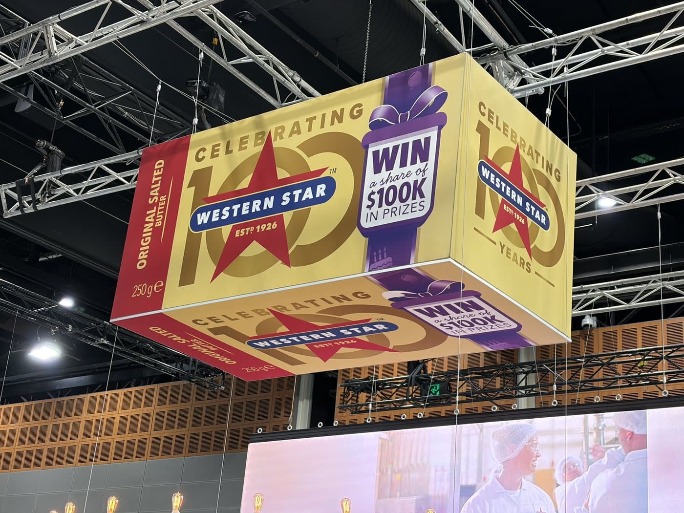 Suspended printed sign above an exhibition stand