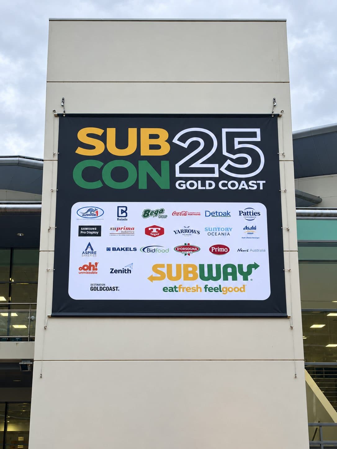 Building banner with event branding and sponsor logos